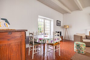 Un coin repas comprenant une table ronde, des chaises et un buffet en bois.