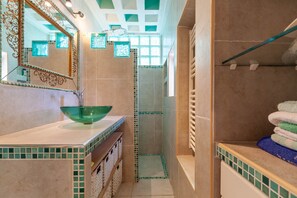 A bathroom with a green glass bowl sink, a large mirror, and a shower area with a tiled floor. - Apartment 'Fleur De Pampa' with Pool, Wi-Fi, and Air Conditioning (Cassis)