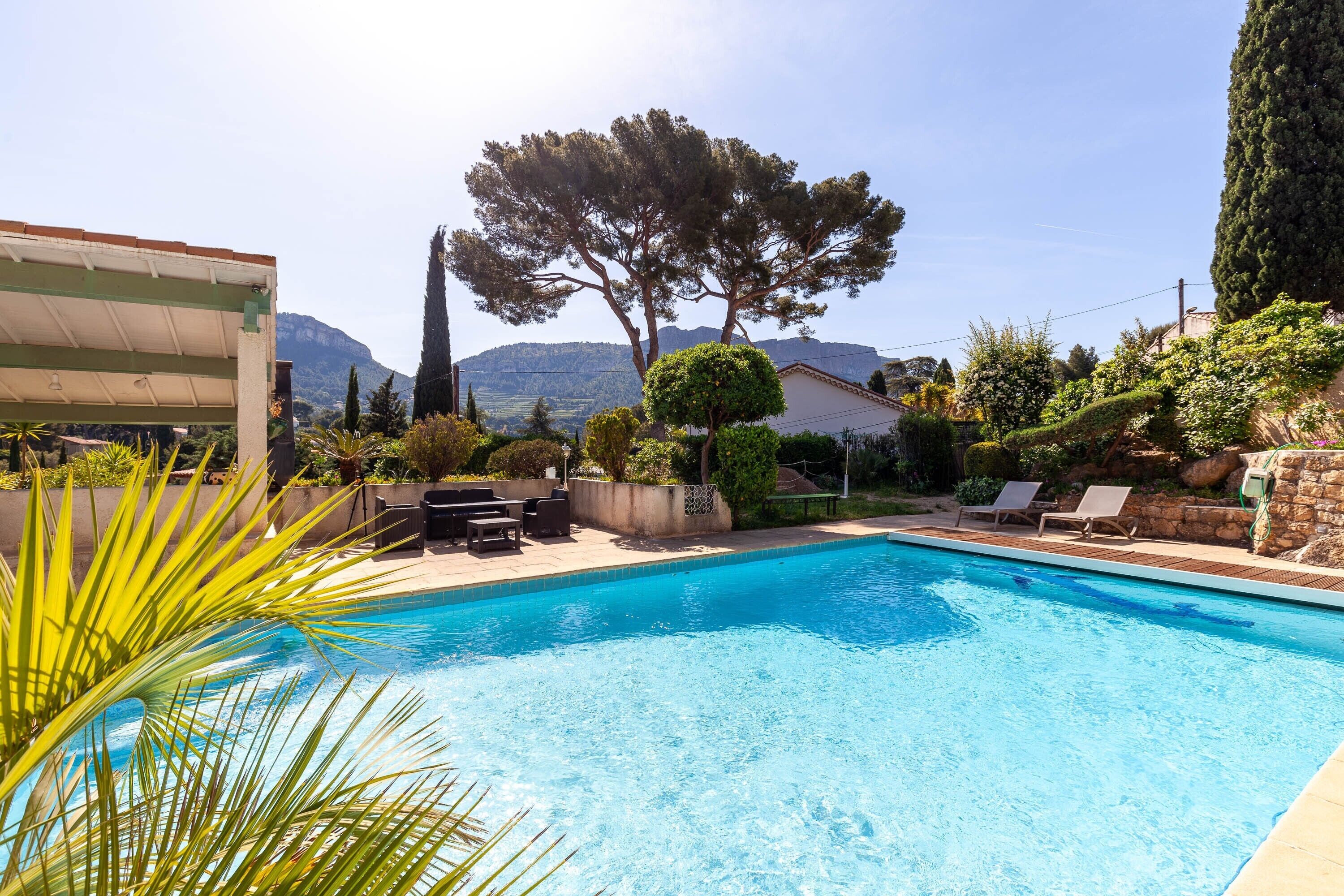A swimming pool with lounge chairs and a view of mountains.