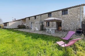 A stone building with a patio area, outdoor seating, and a grassy lawn. - Holiday Home Les Naudines with Shared Pools – Near Bergerac (gageac et rouillac)