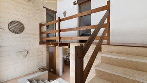 Un escalier en bois mène à une mezzanine d’où l’on a vue sur la salle à manger.