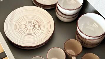 A drawer containing neatly stacked plates and cups.