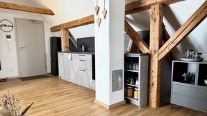 Una cocina moderna con vigas de madera, armarios grises y encimera negra.