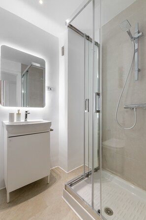 Een douche, een haardroger, handdoeken, toiletpapier