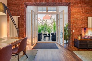 Une pièce moderne avec un mur en briques, une table à manger en bois et une vue sur l’extérieur.