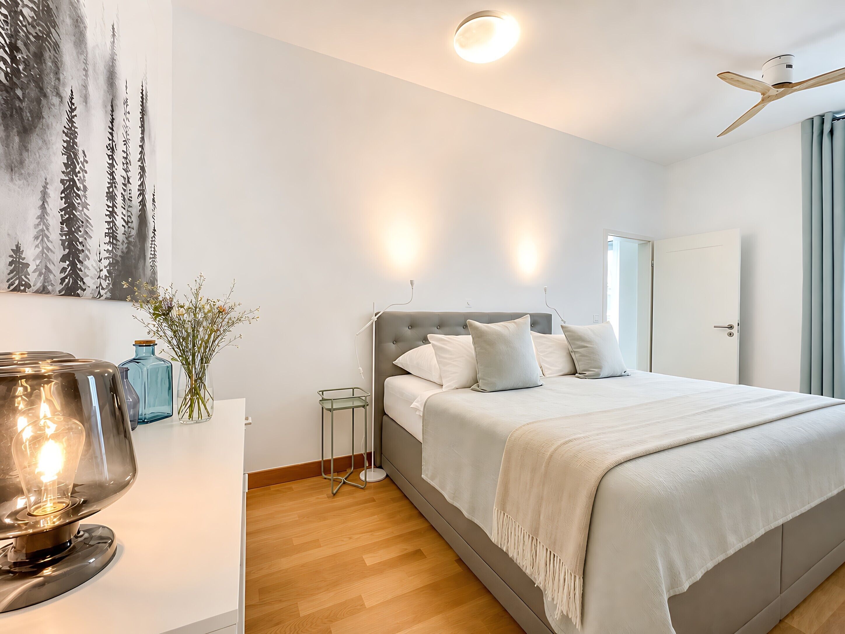 Une chambre à coucher avec un lit, une table de chevet, une lampe et un tableau au mur.