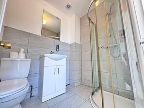 Een douche, handdoeken, zeep, shampoo