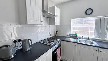 Een koelkast met diepvriezer, een microgolfoven, een oven