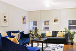 Un salon moderne avec deux canapés, une table basse et des coussins décoratifs.
