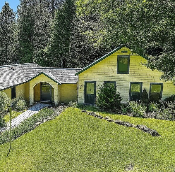 A yellow building with a sloped roof, a front entrance, and a small porch. - Pitcher Perfect Truly the perfect  LAKEFRONT Maine getaway (Lincolnville)