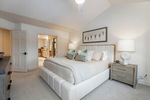 Un dormitorio con una cama grande, mesitas de noche y un cuadro en la pared.