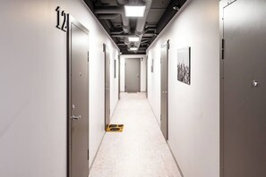 A hallway with doors numbered 12 to 7, leading to individual rooms. - Cozy 1BR in Old Town + Parking (Vilnius)