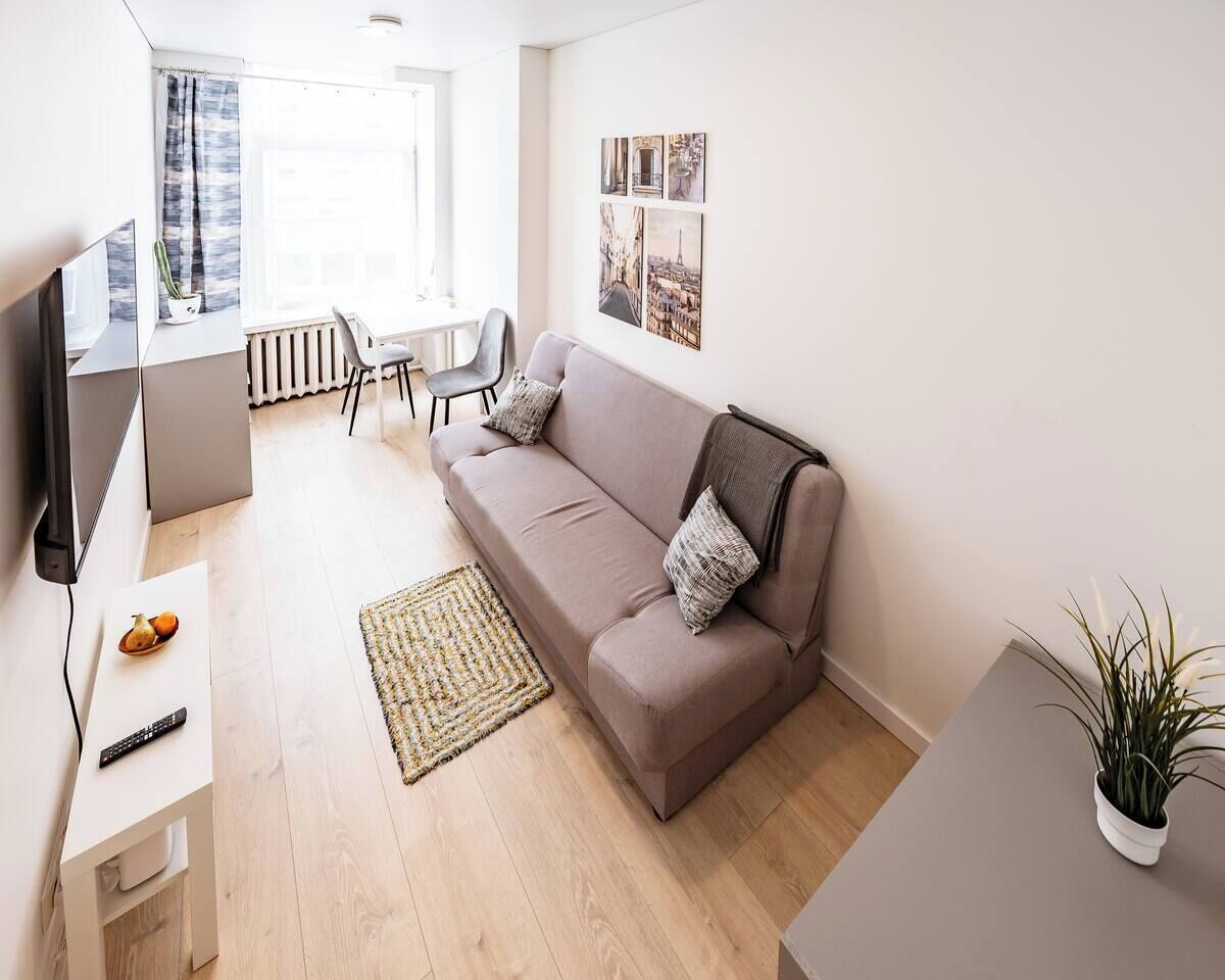 Un salon moderne comprenant un canapé, une table basse, un téléviseur et un coin repas avec des chaises.