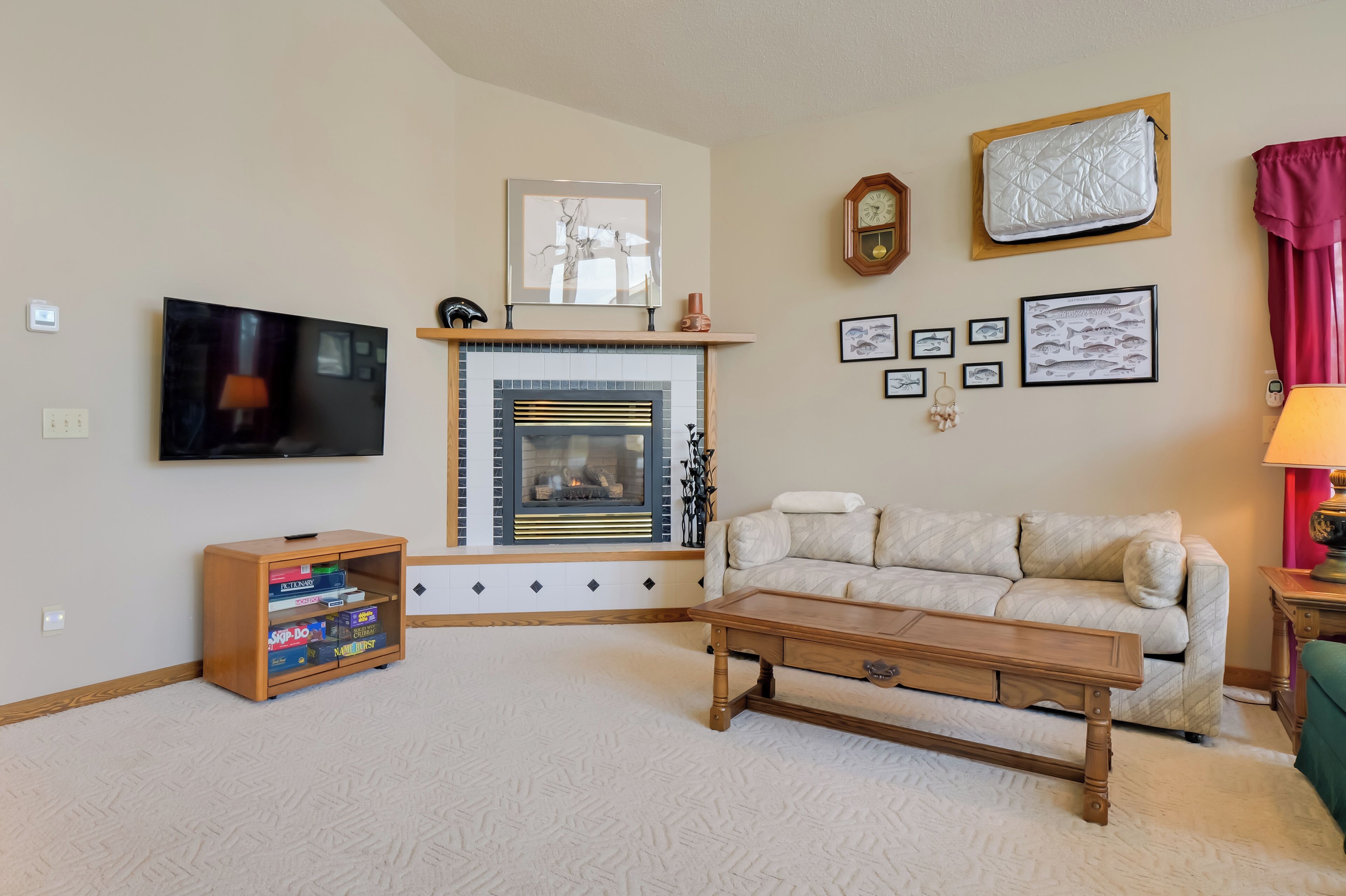 A living room with a fireplace, a television, a sofa, a coffee table, and a bookshelf.