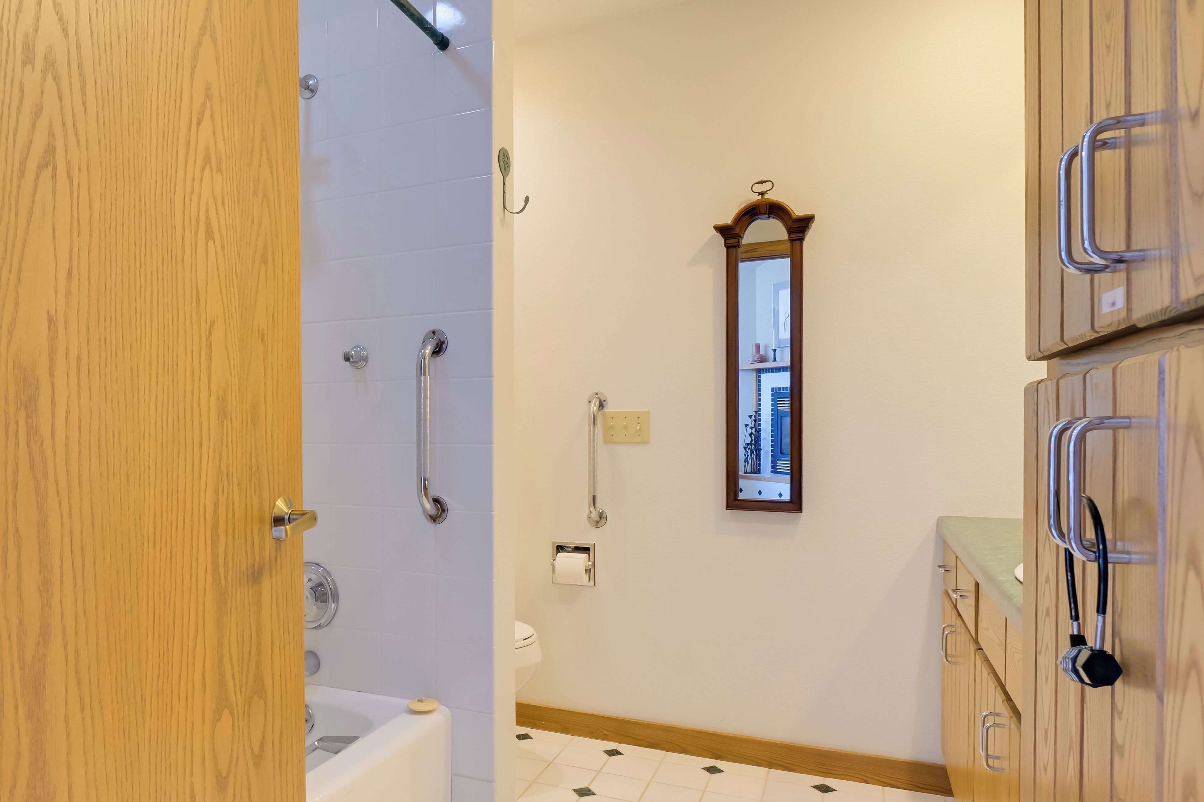 A bathroom with a bathtub, a toilet, and a mirror.