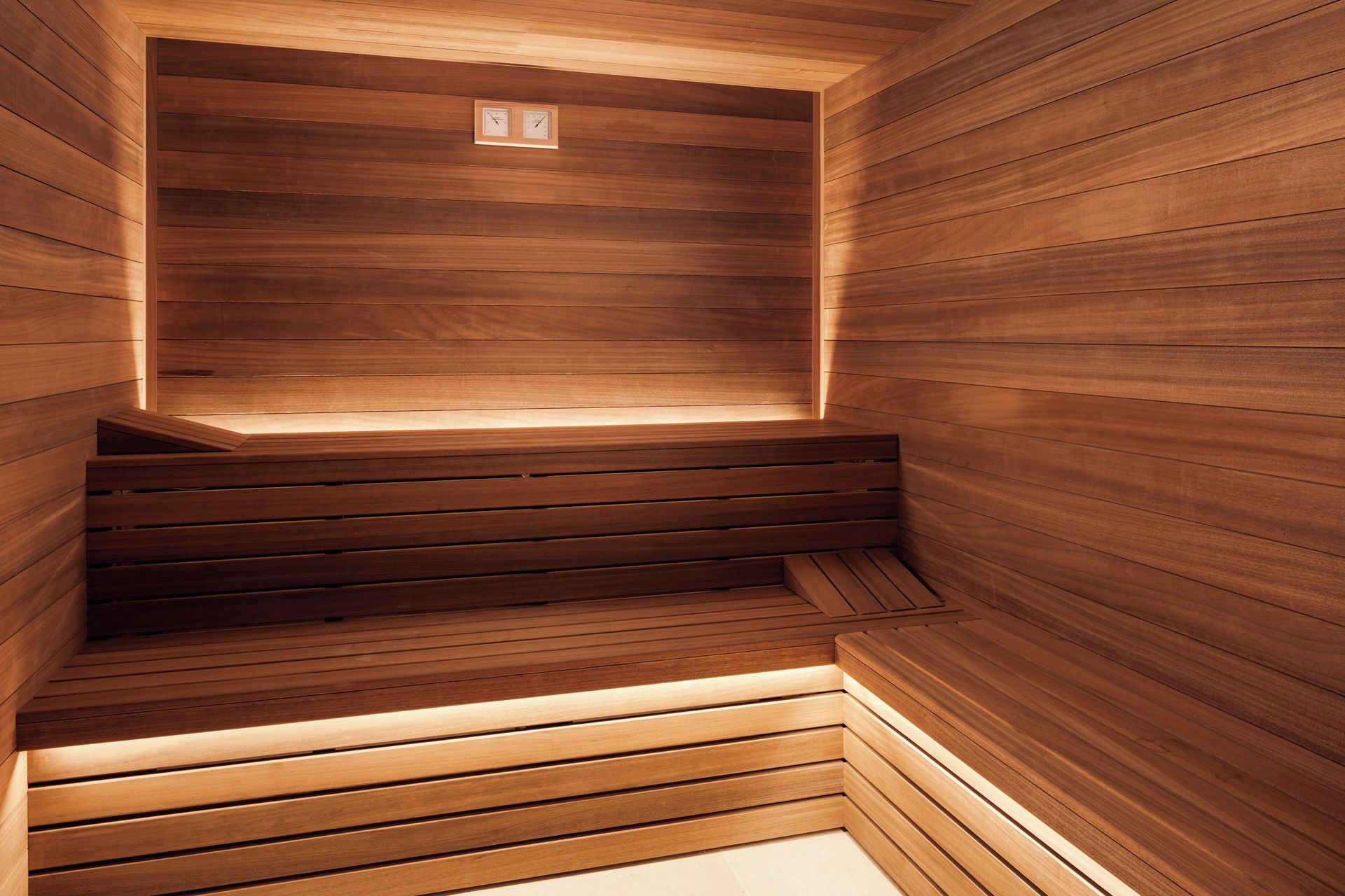 A wooden sauna with a bench and a small window.