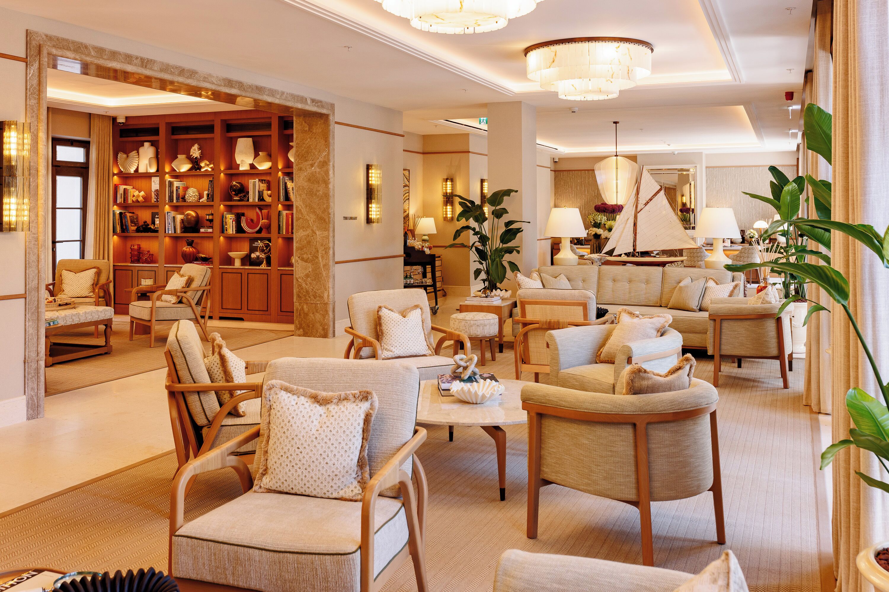 A spacious lobby with a library, comfortable seating, and a sailboat model.