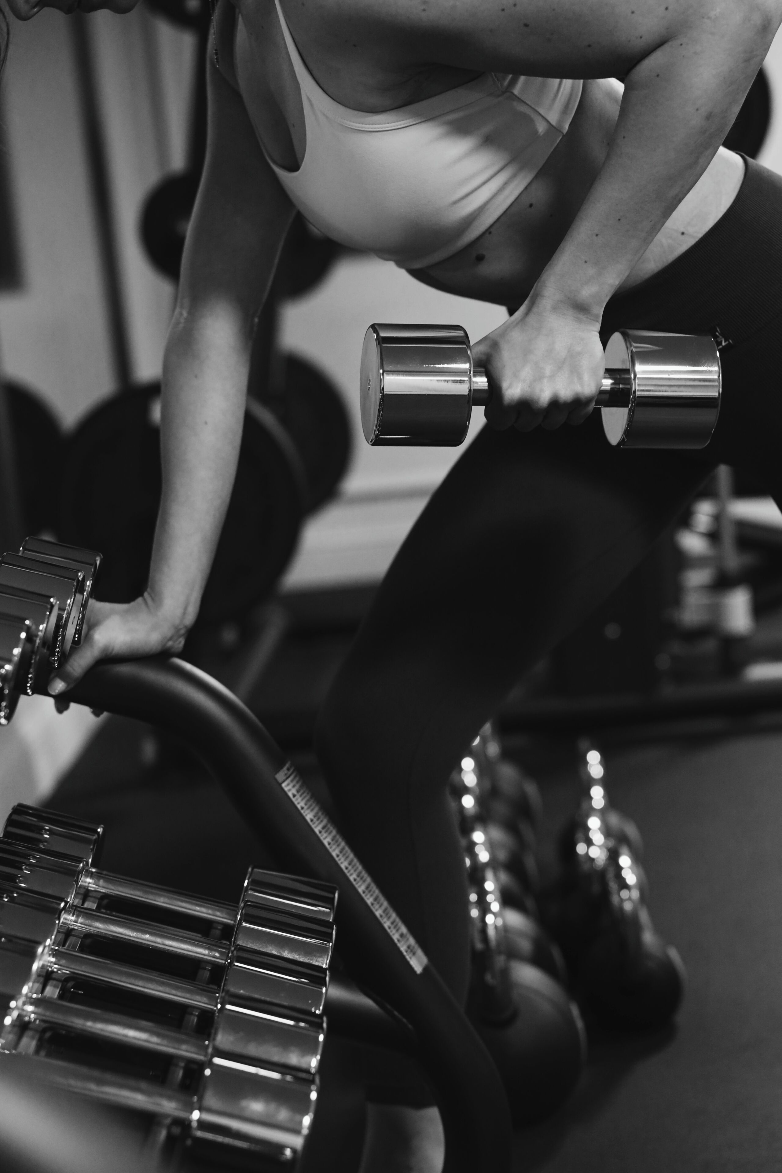 A person using a dumbbell in a gym setting.