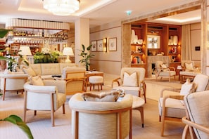 A hotel lobby with a bar, seating area, and a fireplace.
