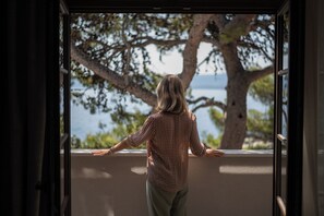 A person standing at a balcony with a view of a tree and water. - The Bristol Bol, New in 2026 (Bol)