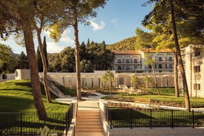 A hotel with a central courtyard, a staircase leading to the entrance, and a building with multiple balconies. - The Bristol Bol, New in 2027 (Bol)