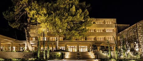 Un hotel de varios pisos con fachada de piedra, un árbol grande en la parte delantera y un cartel que dice 'THE BRISTOL'.