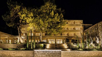 A multi-story hotel with a stone facade, a large tree in front, and a sign reading 'THE BRISTOL'.