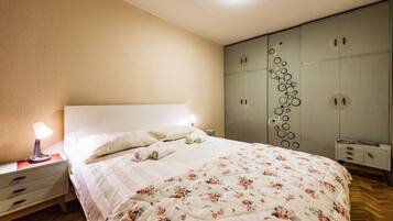 A bedroom with a bed, bedside tables, a wardrobe, and a lamp.