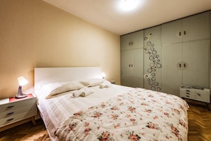 A bedroom with a bed, bedside tables, a wardrobe, and a lamp. - Cozy Apartment in Kaunas with Free Parking. (Kaunas)