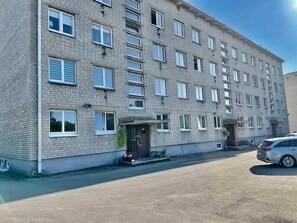 A multi-story residential building with a brick facade, multiple windows, and a gated entrance. - Cozy Apartment in Kaunas with Free Parking. (Kaunas)
