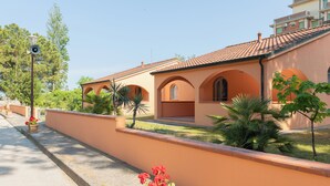 A building with a terracotta facade, arched windows, and a tiled roof. - The Charming Marina Village Tipo3-3 Bedroom Villa 6 Persons (Comacchio)