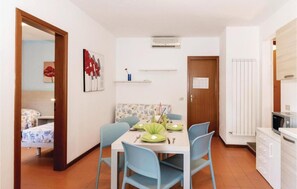 A compact living space with a dining area, kitchenette, and a bedroom. - The Charming Marina Village Tipo3-3 Bedroom Villa 6 Persons (Comacchio)