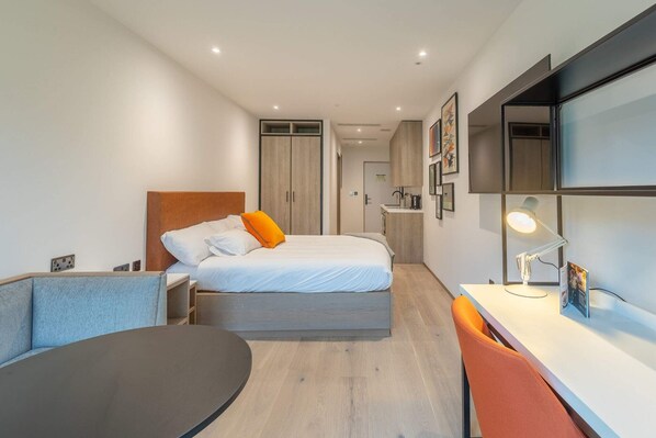 A modern hotel room with a bed, a desk, a chair, and a small table. - Student Only Space St.Andrews (St. Andrews)