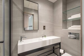 A modern bathroom with a large mirror, a white sink, and a glass shelf with towels. - Student Only Space St.Andrews (St. Andrews)