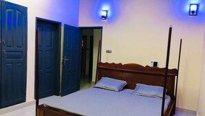 A bedroom with a four-poster bed, two wall-mounted lights, and a door leading to another room. - Mariagletta Cozy Villa (Abomey-Calavi)