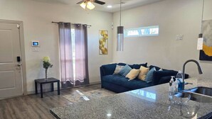 A modern kitchen with a granite countertop, stainless steel sink, and a ceiling fan. - Houston Extended Stay Near Downtown (Houston)