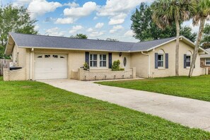 A single-story house with a garage, a front porch, and a well-maintained lawn. - Heated Pool, Game Room, Everything Packed for You (Pensacola)