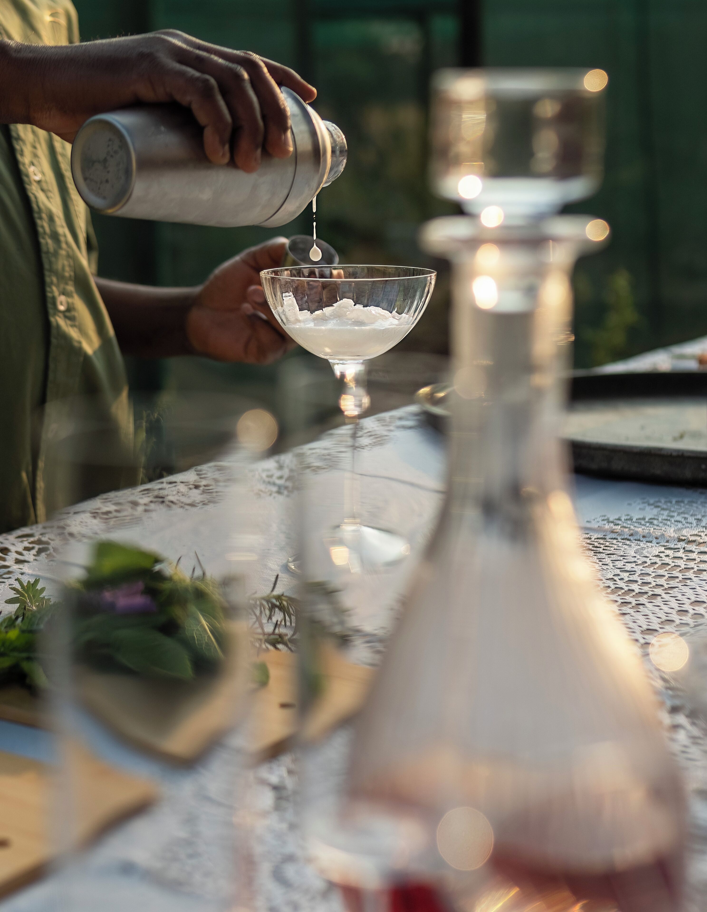 Une personne verse un liquide d’un shaker dans un verre à martini.