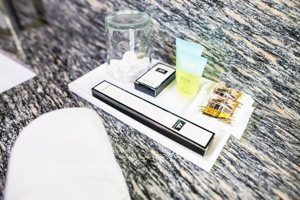 A tray with toiletries on a granite countertop.