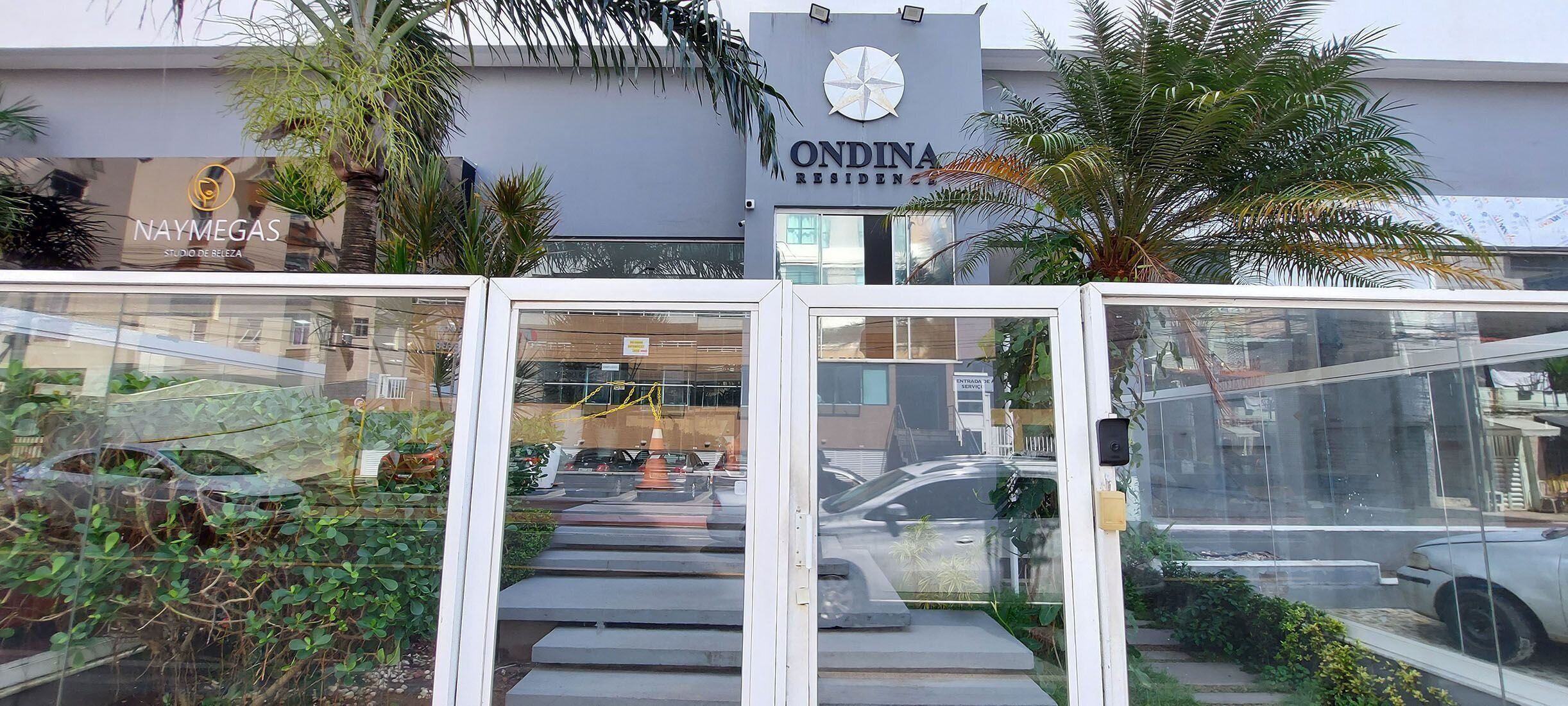 Un edificio residencial con un letrero que dice 'ONDINA RESIDENCE' y un letrero de 'NAYMEGAS'.