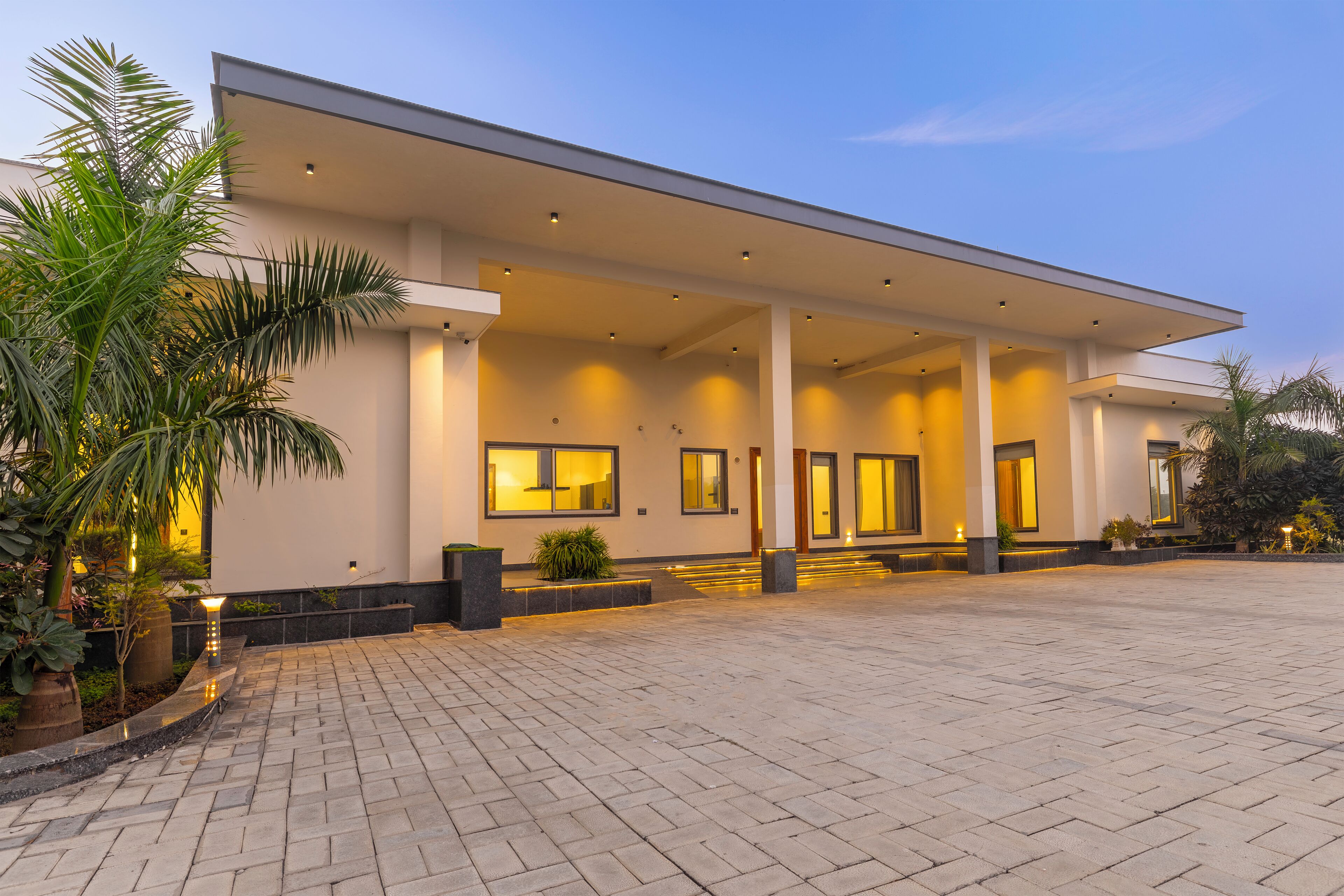 A modern building with a covered entrance, large windows, and a paved driveway.