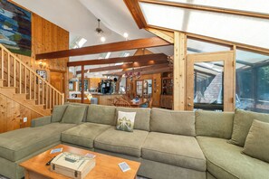 Ein Holzinnenraum mit einem Ecksofa, einer Holztreppe und einer Küchenzeile.