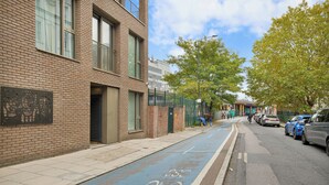 A street with a bike lane, brick buildings, and parked cars. - 2bed 2bath close to Tower Bridge (London)