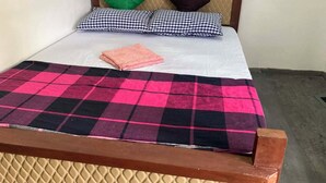A bed with a checkered blanket, two pillows, and a folded towel. - Pap de home (Weligama, Weligama, Hettiweediya)