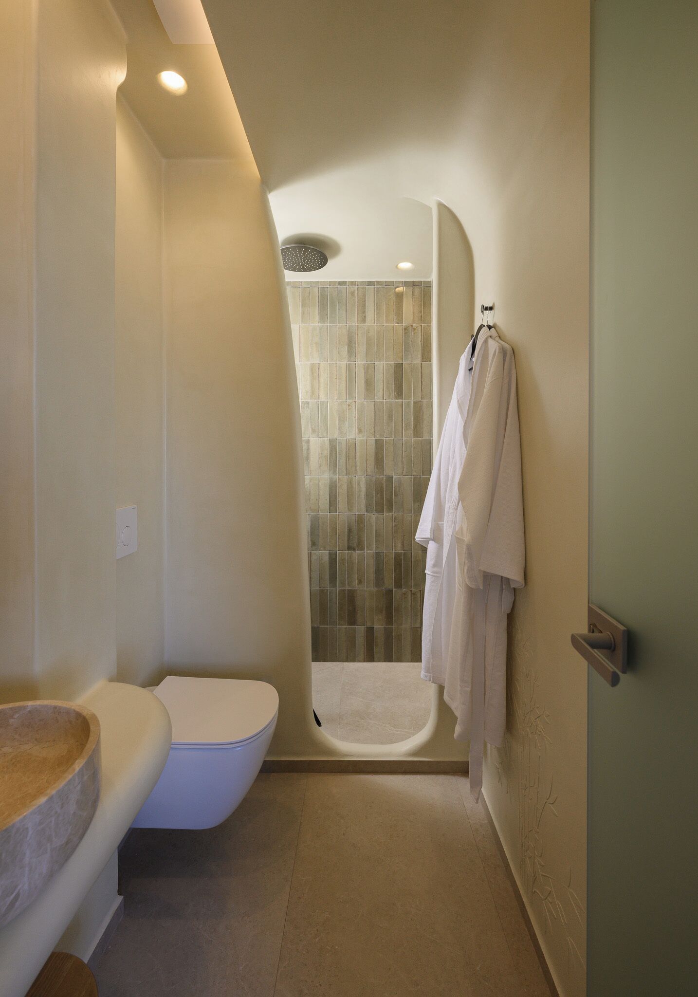 A bathroom with a toilet, a sink, a shower, and a towel rack.