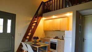 Una cocina compacta con comedor, una escalera y una puerta.