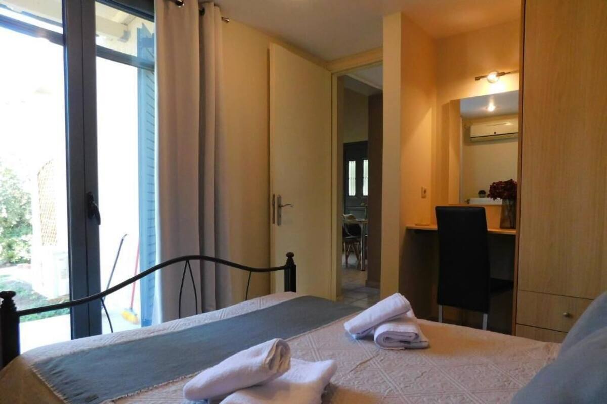 Habitación de hotel con cama, escritorio y silla. Hay toallas sobre la cama.