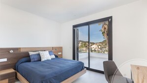 Une chambre moderne avec un lit, une chaise et une vue sur l’extérieur.