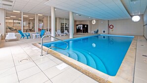 An indoor swimming pool with clear water, surrounded by lounge chairs and a tiled floor. - Flat with a balcony overlooking the sea, 50 metres from the beach (Plougonvelin)