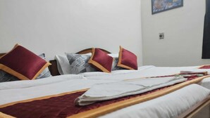 Ein Hotelzimmer mit zwei Betten, jeweils mit weißer Bettwäsche und roten Kissen.